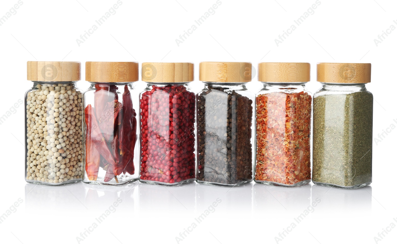 Photo of Different aromatic spices in glass jars isolated on white