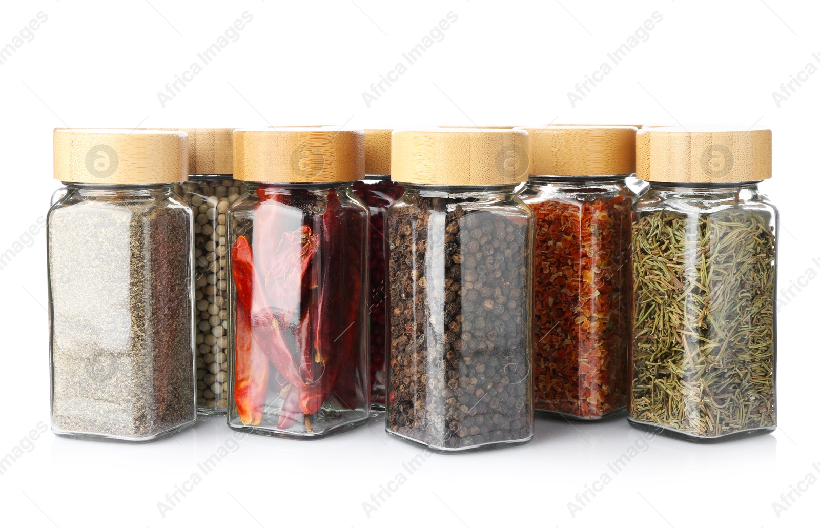 Photo of Different aromatic spices in glass jars isolated on white