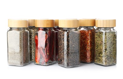 Photo of Different aromatic spices in glass jars isolated on white