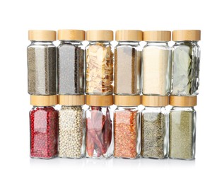Photo of Different aromatic spices in glass jars isolated on white