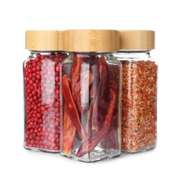Photo of Different aromatic spices in glass jars isolated on white