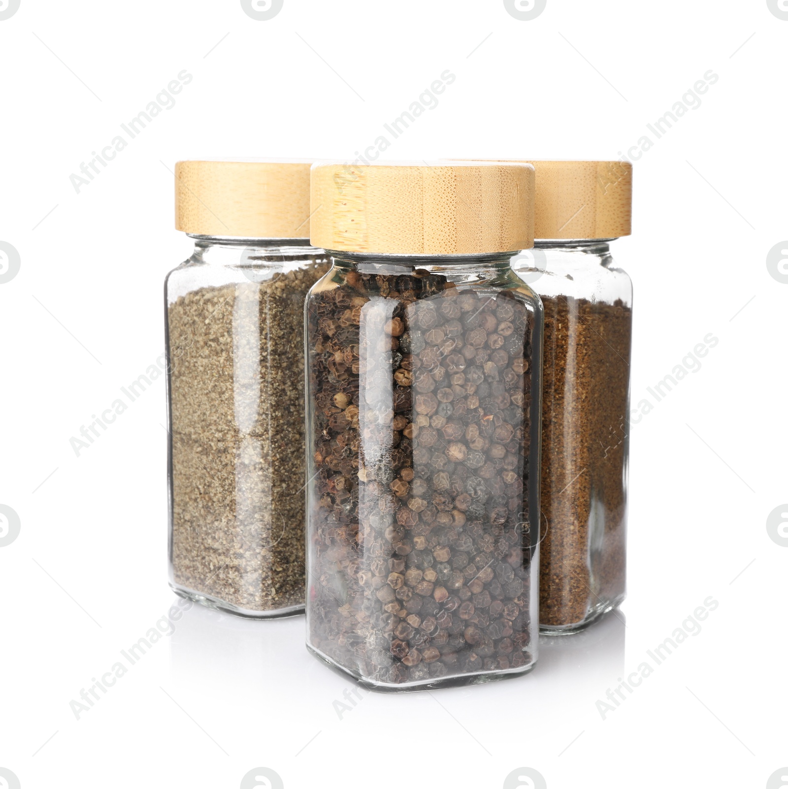 Photo of Different aromatic spices in glass jars isolated on white