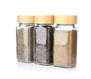 Photo of Different aromatic spices in glass jars isolated on white