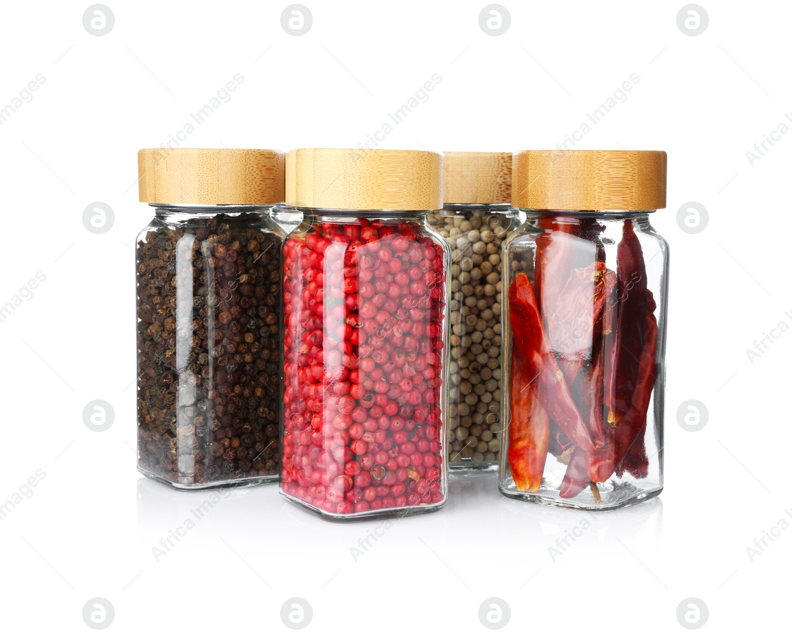 Photo of Different aromatic spices in glass jars isolated on white