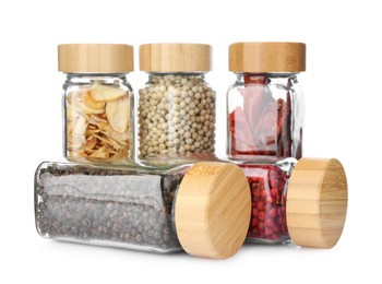 Photo of Different aromatic spices in glass jars isolated on white