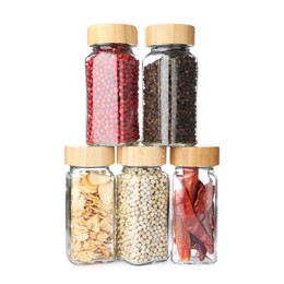 Photo of Different aromatic spices in glass jars isolated on white