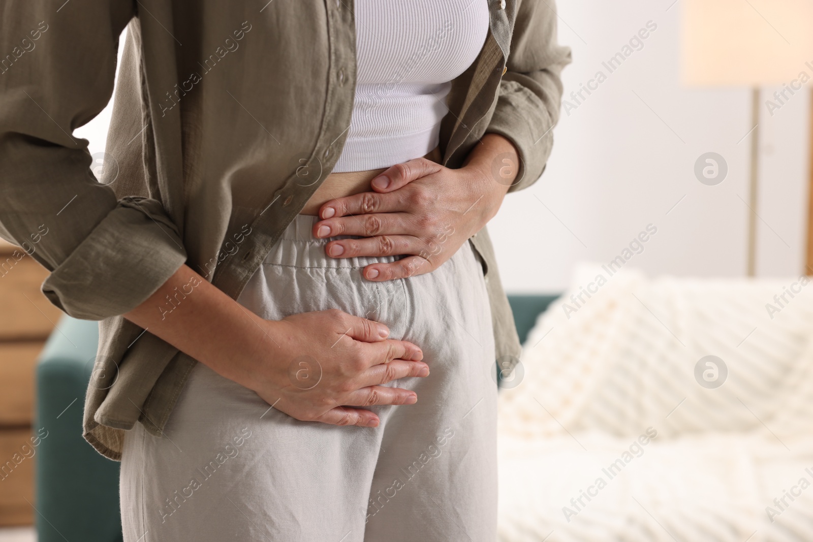Photo of Woman suffering from cystitis symptoms at home, closeup. Space for text