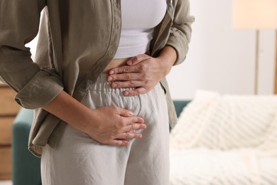Photo of Woman suffering from cystitis symptoms at home, closeup. Space for text