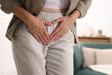 Photo of Woman suffering from cystitis symptoms at home, closeup. Space for text