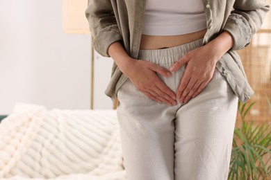 Photo of Woman suffering from cystitis symptoms at home, closeup. Space for text