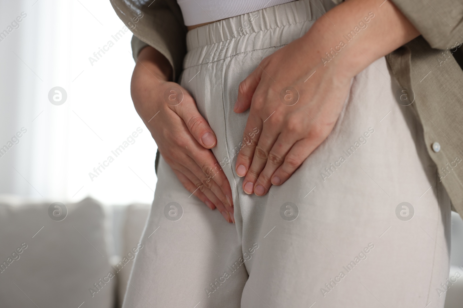 Photo of Woman suffering from cystitis symptoms at home, closeup. Space for text