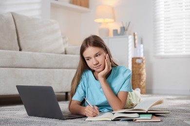Photo of Teenage girl studying online on floor at home