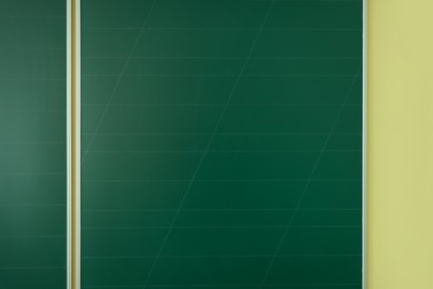 Photo of Green chalkboard on wall in classroom, closeup