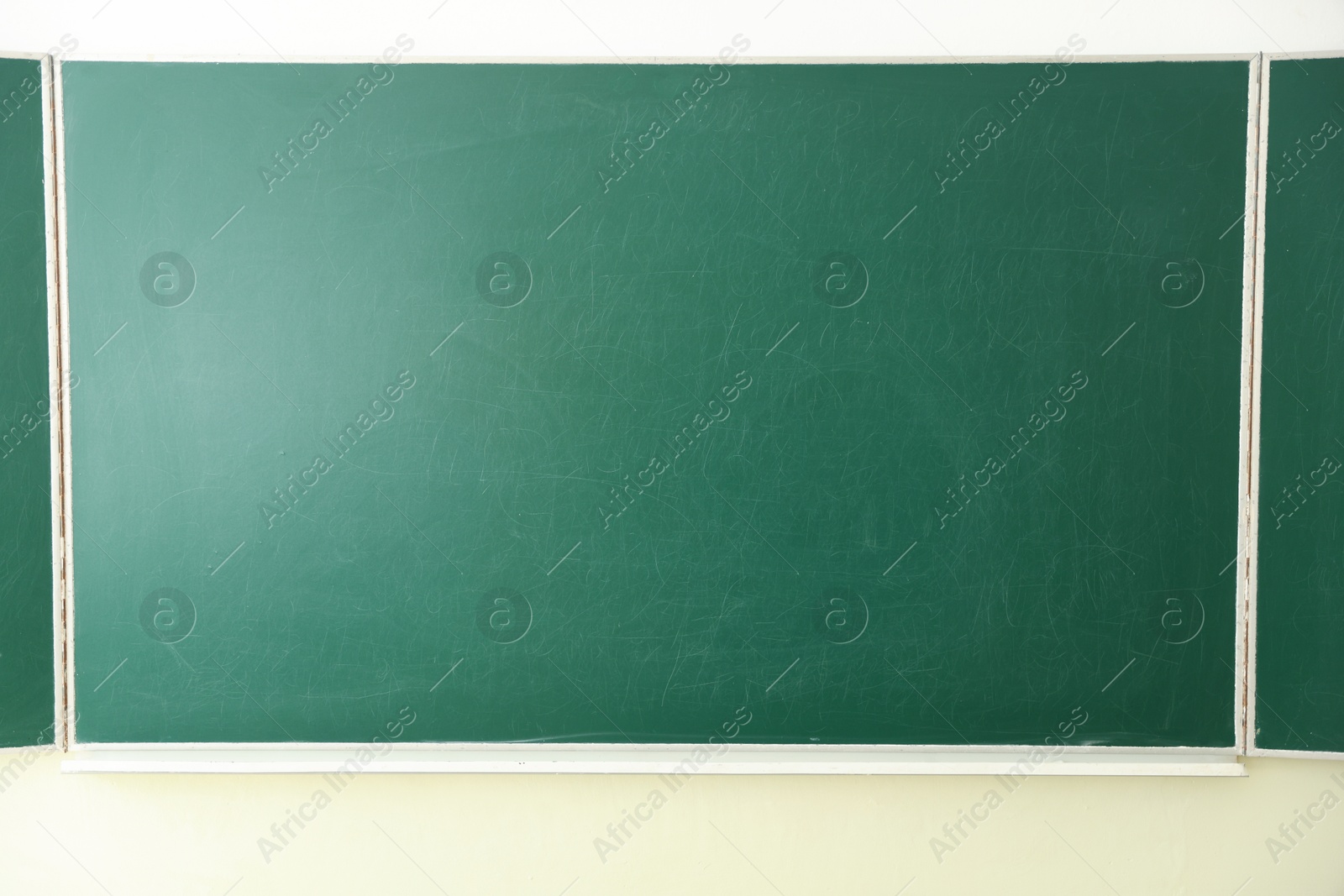 Photo of Green chalkboard on wall in classroom, closeup