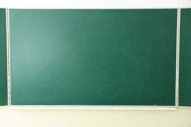 Photo of Green chalkboard on wall in classroom, closeup