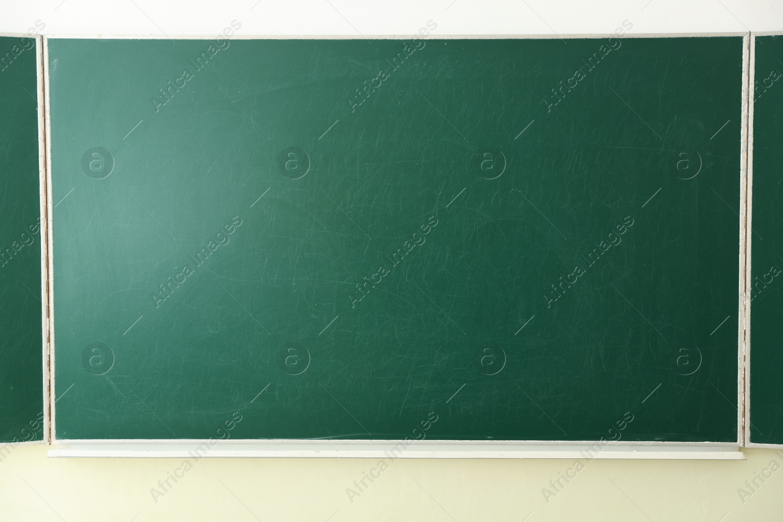 Photo of Green chalkboard on wall in classroom, closeup