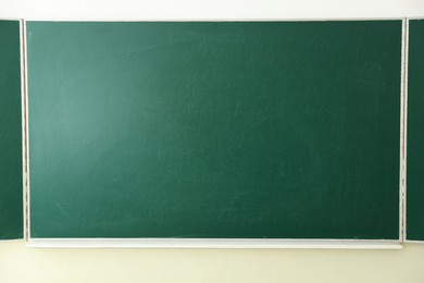 Photo of Green chalkboard on wall in classroom, closeup