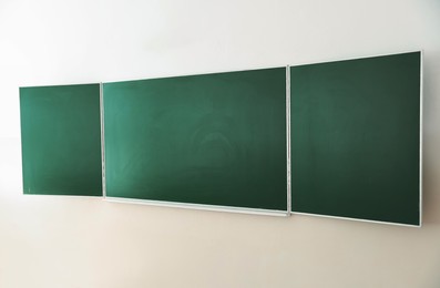 Photo of Green chalkboard on wall in classroom. Back to school