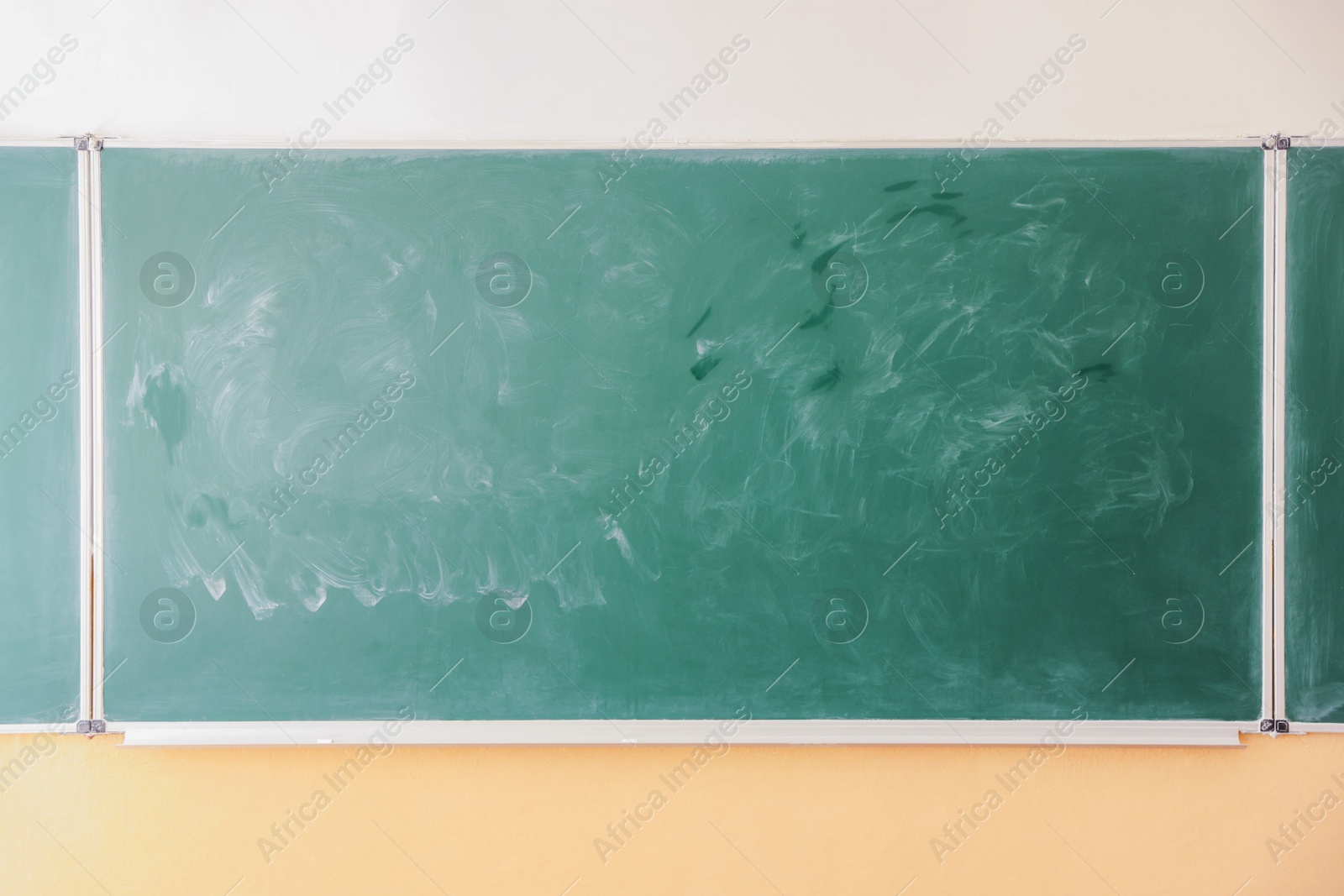 Photo of Green chalkboard on wall in classroom. Back to school