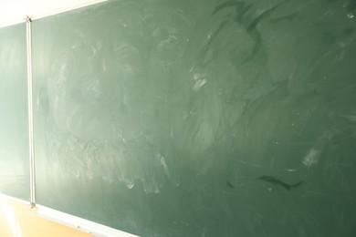 Photo of Green chalkboard on wall in classroom, closeup