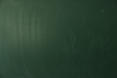 Photo of Blank green chalkboard as background, closeup view