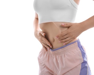 Photo of Woman doing abdominal vacuum exercise on white background, closeup
