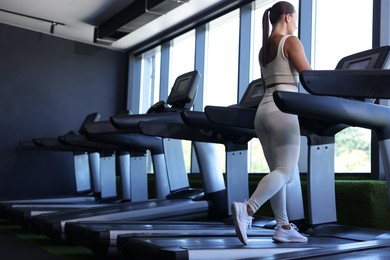 Photo of Athletic woman training on treadmill in gym, low angle view