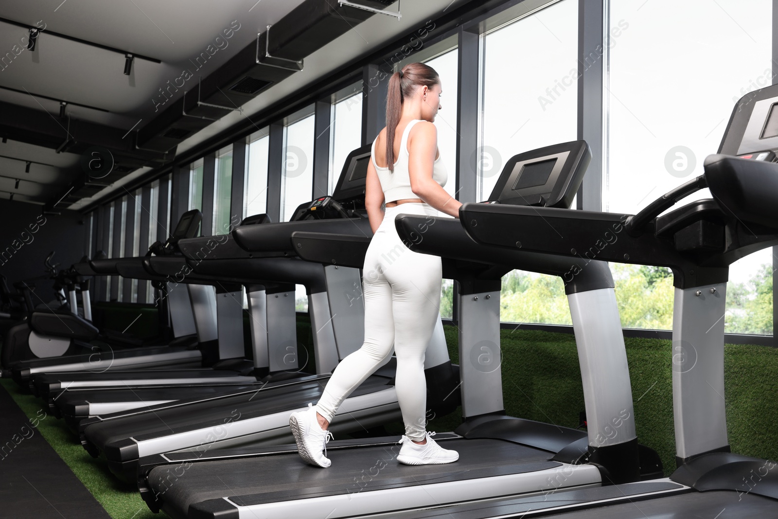 Athletic woman training on treadmill in gym, low angle view Photo of Athletic woman training on treadmill in gym, low angle view