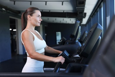 Photo of Athletic woman training on treadmill in gym