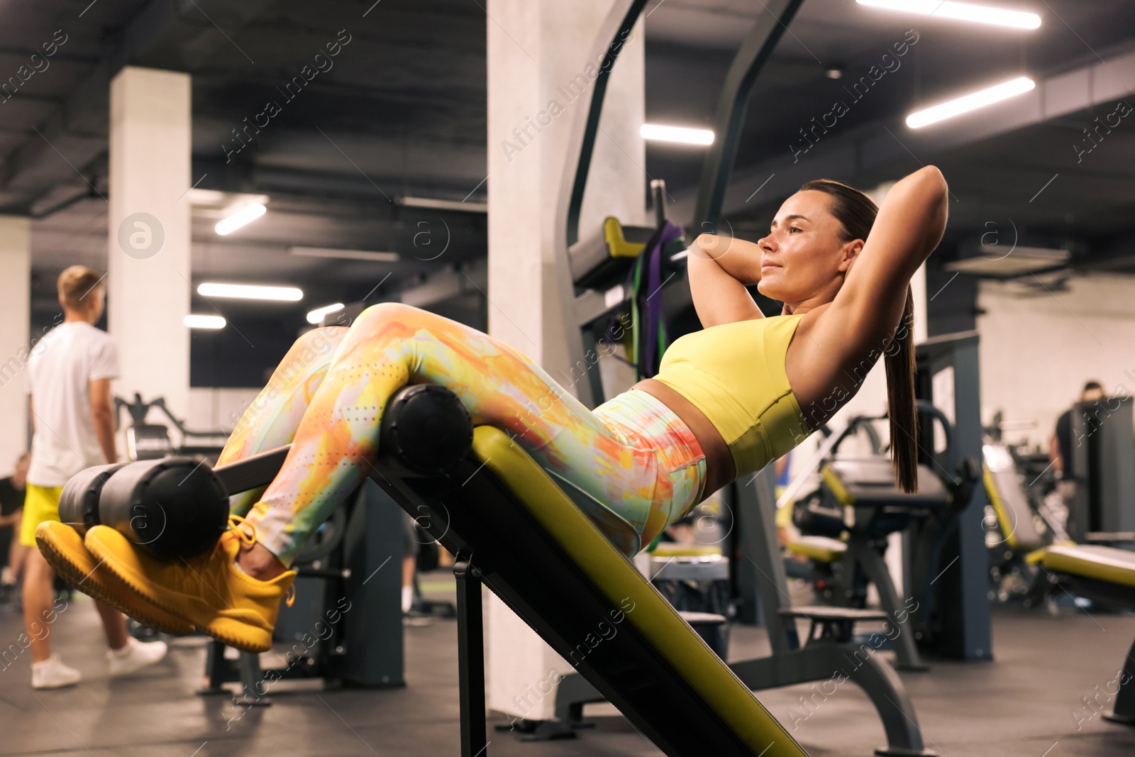 Photo of Athletic woman training on roman chair in gym