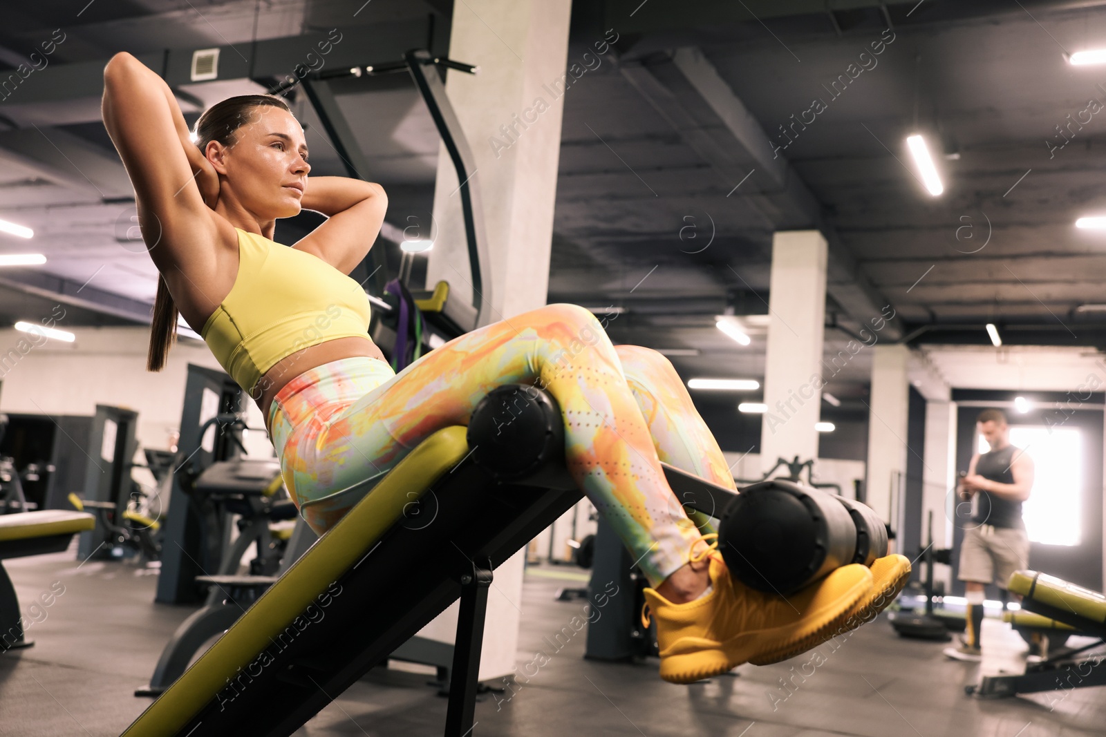 Photo of Athletic woman training on roman chair in gym, low angle view
