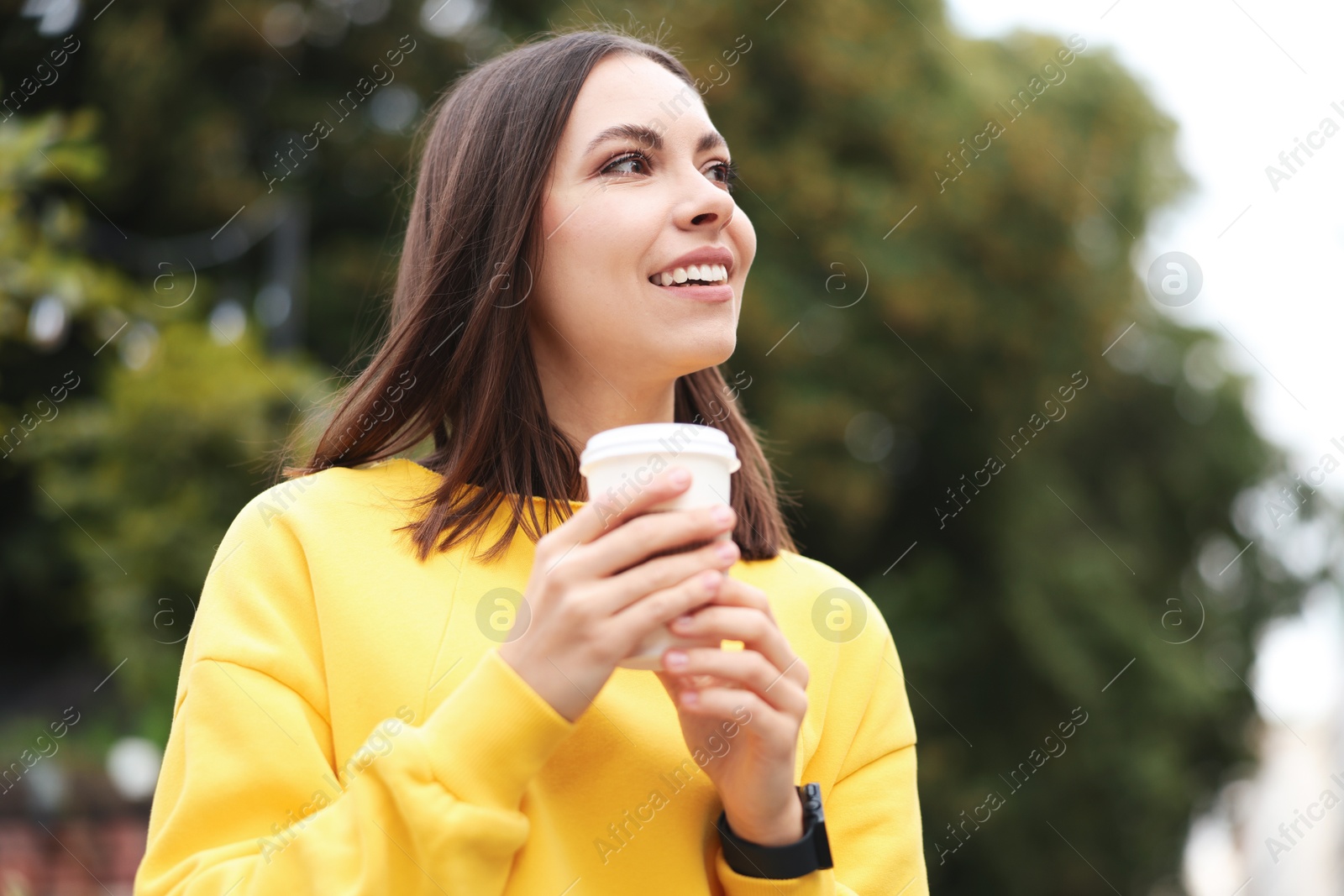 Photo of Coffee to go. Woman with paper cup of drink on city street, space for text