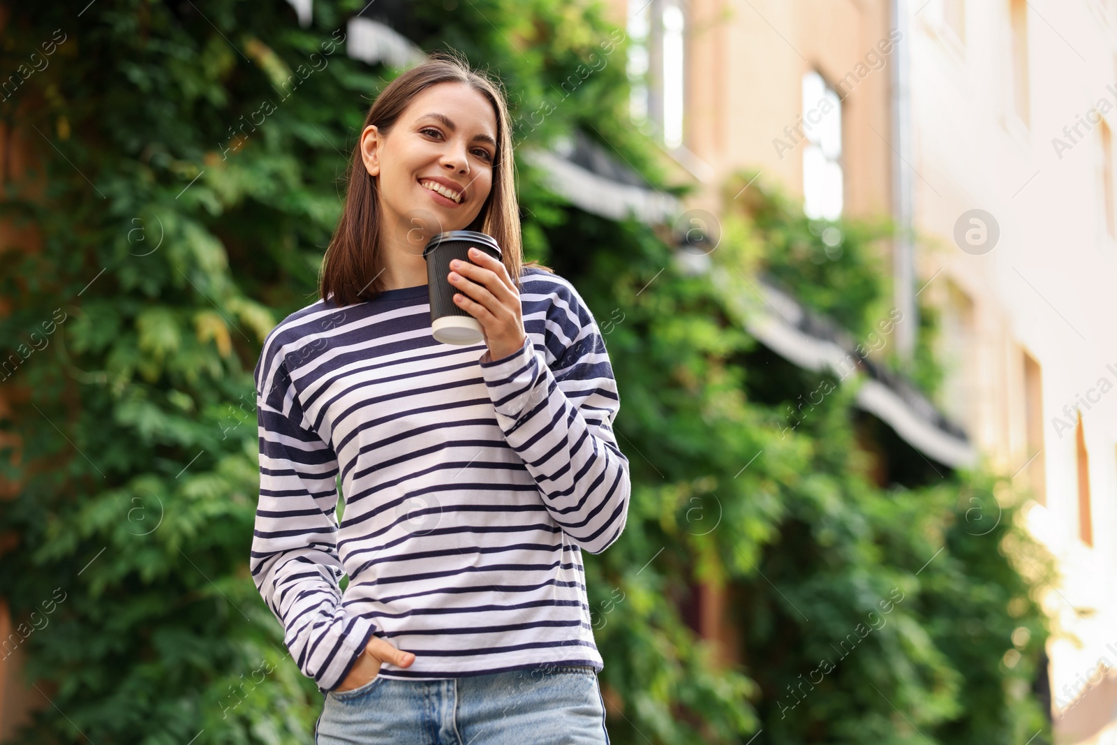 Photo of Coffee to go. Woman with paper cup of drink outdoors, space for text