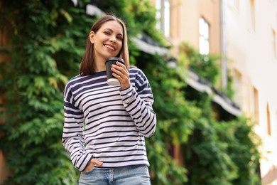 Photo of Coffee to go. Woman with paper cup of drink outdoors, space for text