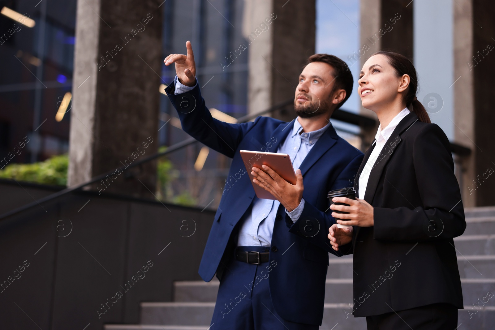 Photo of Coffee to go. Woman with paper cup of drink and her business partner during meeting outdoors, space for text