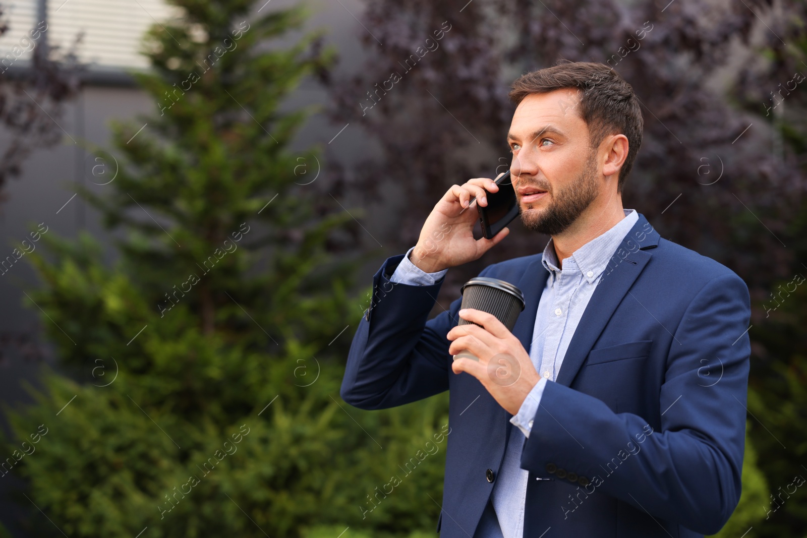 Photo of Coffee to go. Man with paper cup of drink talking on smartphone outdoors, space for text