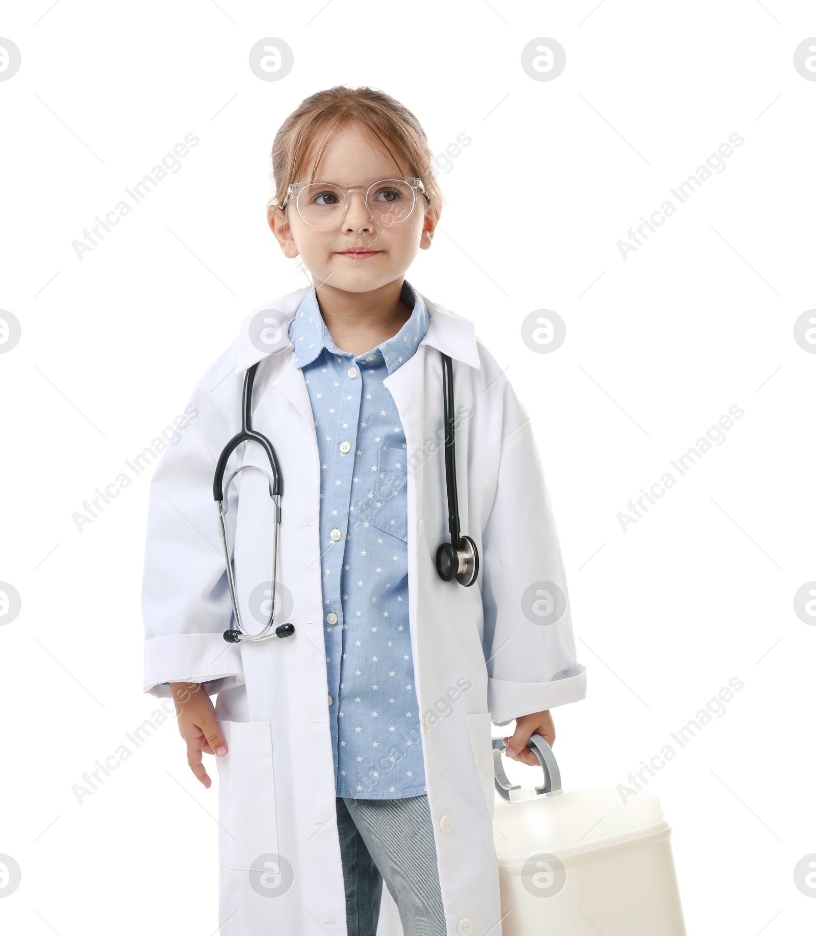 Photo of Choice of profession. Little girl in uniform with stethoscope and case pretending to be doctor on white background
