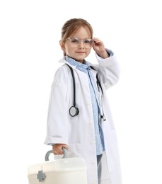 Photo of Choice of profession. Little girl in uniform with stethoscope and case pretending to be doctor on white background