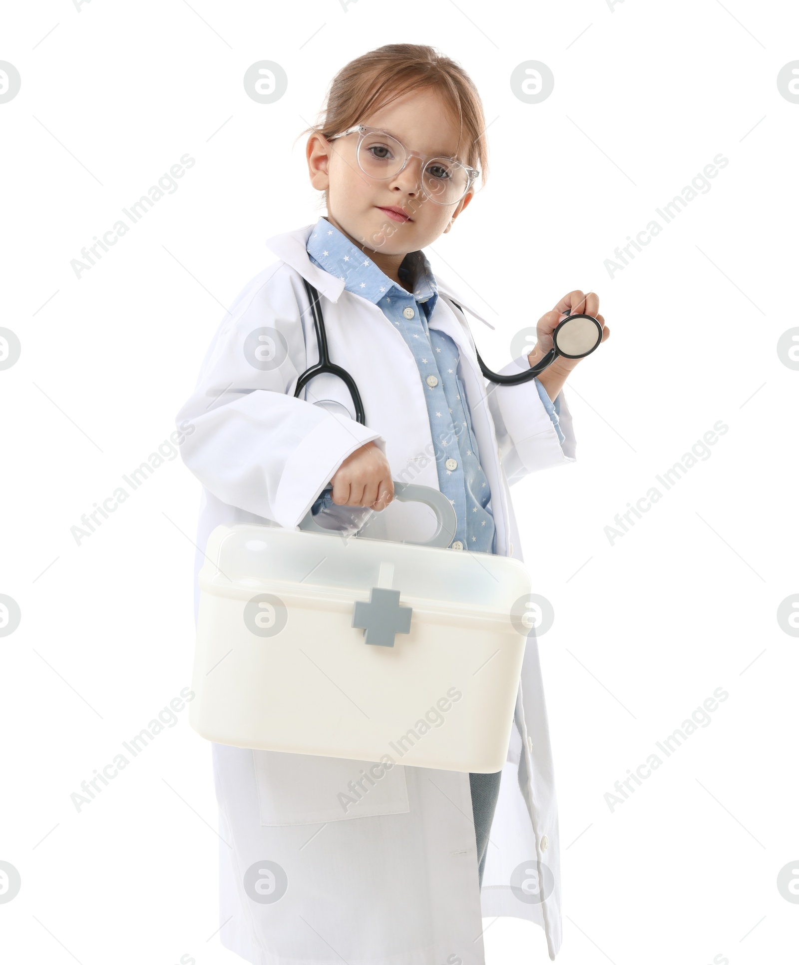 Photo of Choice of profession. Little girl in uniform with stethoscope and case pretending to be doctor on white background
