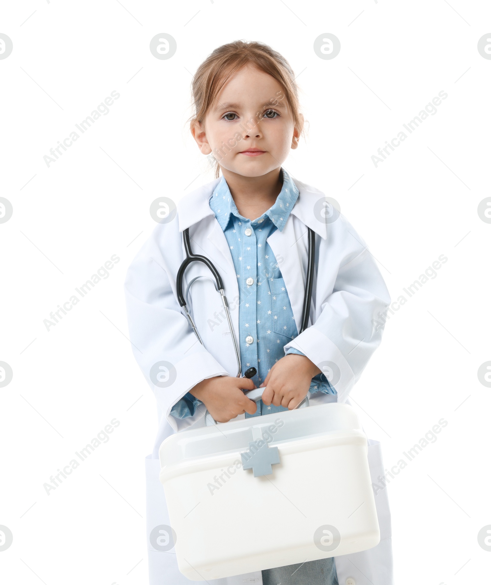 Photo of Choice of profession. Little girl in uniform with stethoscope and case pretending to be doctor on white background