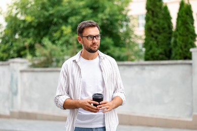 Photo of Coffee to go. Man with paper cup of drink outdoors