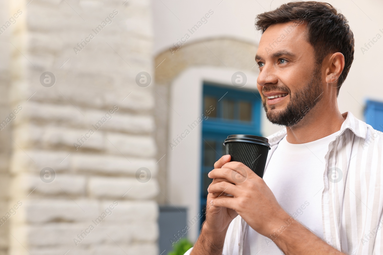 Coffee to go. Man with paper cup of drink outdoors, space for text Photo of Coffee to go. Man with paper cup of drink outdoors, space for text