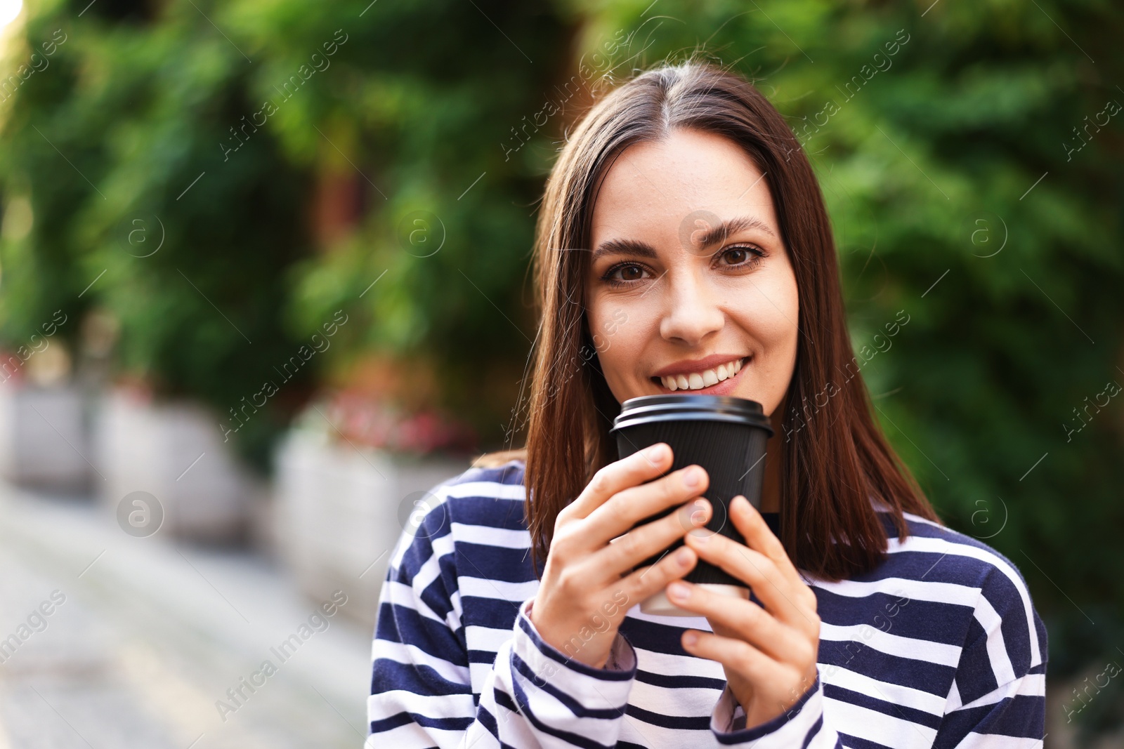Photo of Coffee to go. Woman with paper cup of drink outdoors, space for text