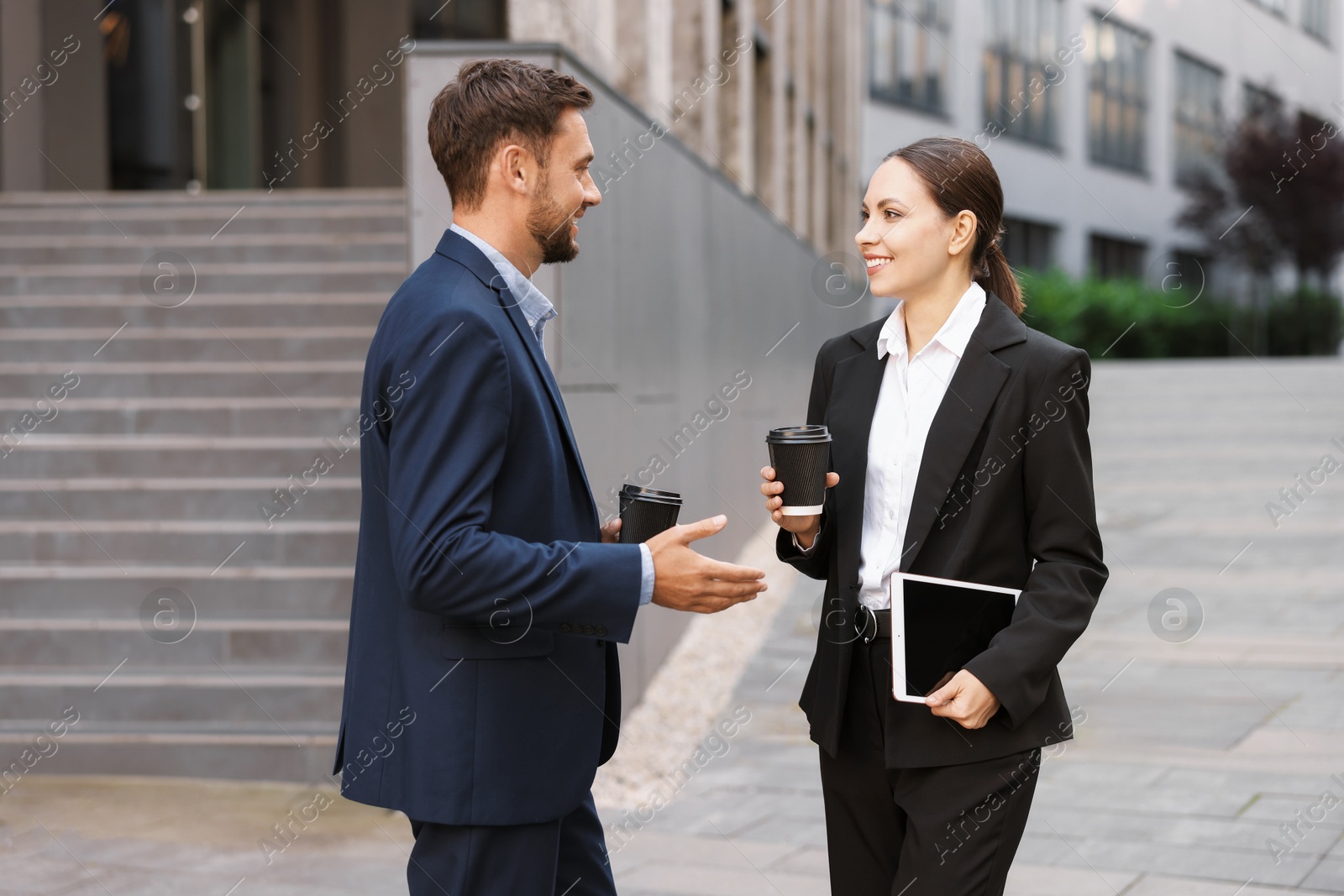 Coffee to go. Businesspeople with paper cups of drinks outdoors Photo of Coffee to go. Businesspeople with paper cups of drinks outdoors