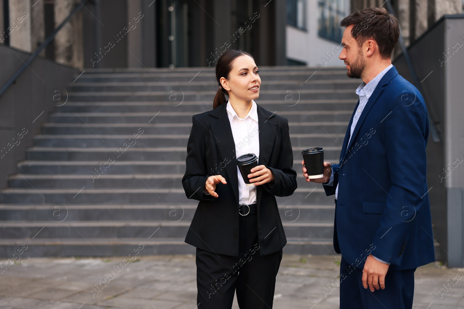Coffee to go. Businesspeople with paper cups of drinks near building outdoors, space for text Photo of Coffee to go. Businesspeople with paper cups of drinks near building outdoors, space for text