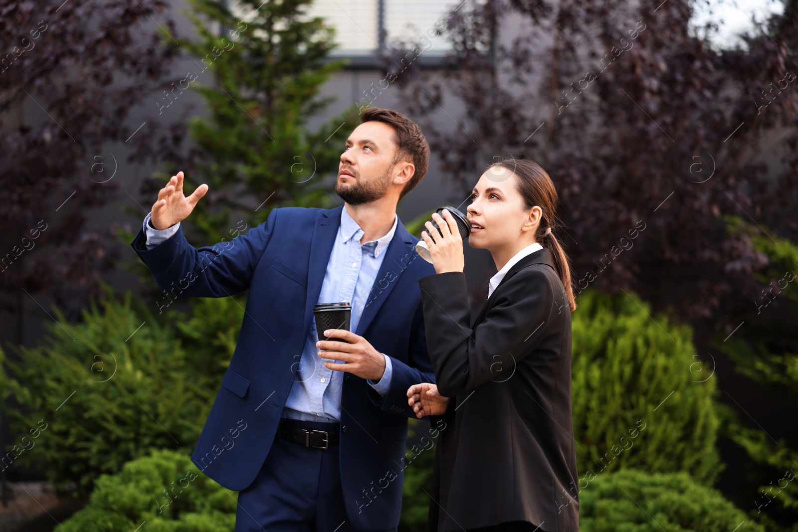 Coffee to go. Businesspeople with paper cups of drinks outdoors Photo of Coffee to go. Businesspeople with paper cups of drinks outdoors