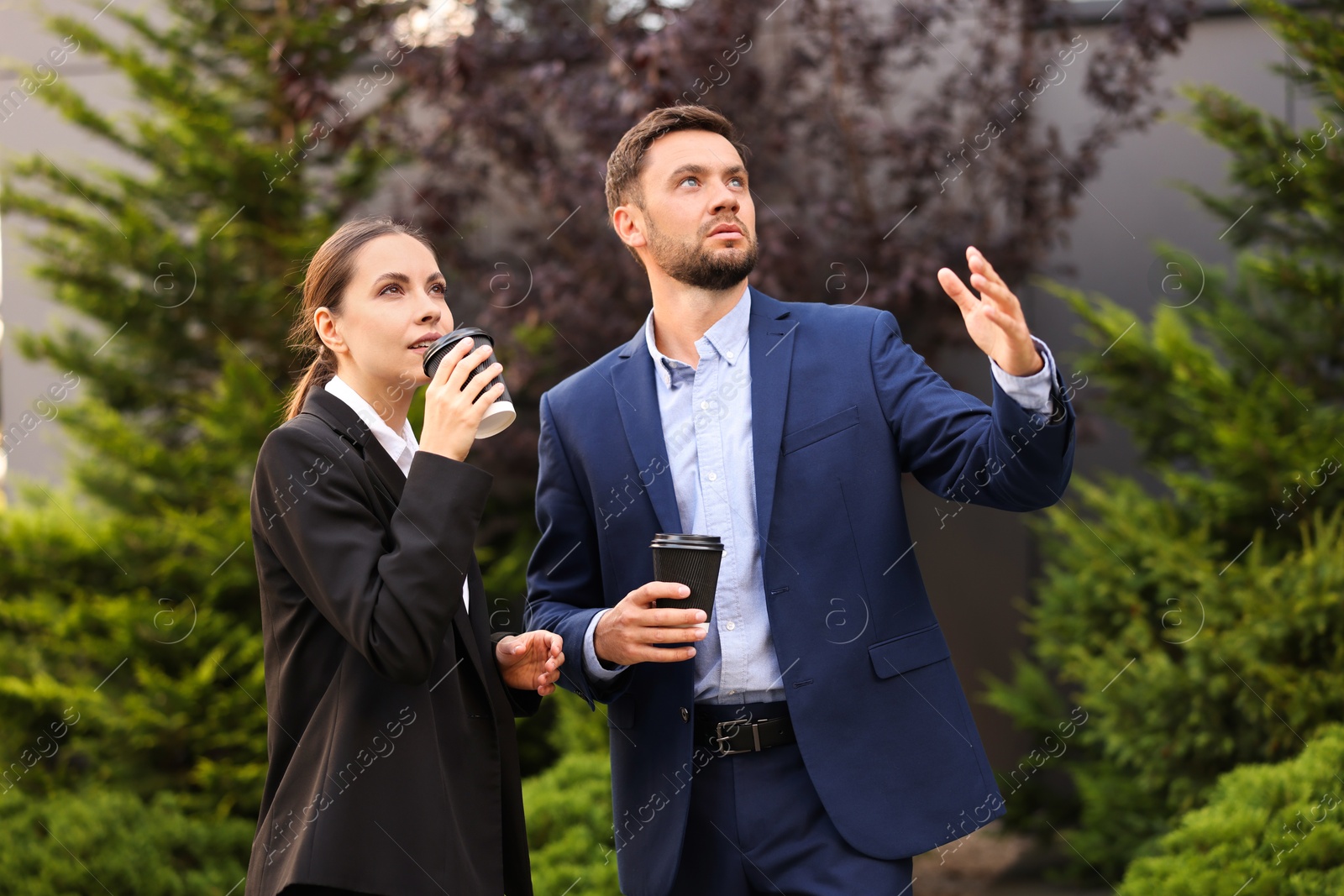 Coffee to go. Businesspeople with paper cups of drinks outdoors Photo of Coffee to go. Businesspeople with paper cups of drinks outdoors