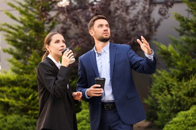 Photo of Coffee to go. Businesspeople with paper cups of drinks outdoors