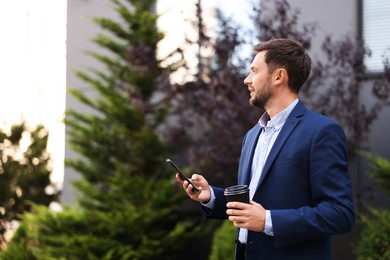 Photo of Coffee to go. Man with paper cup of drink and smartphone outdoors, space for text