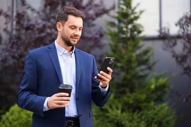 Photo of Coffee to go. Man with paper cup of drink and smartphone outdoors, space for text